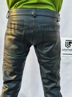 Load image into Gallery viewer, Gay leather man in button fly cowhide pants – rear view with dominant fetish appeal
