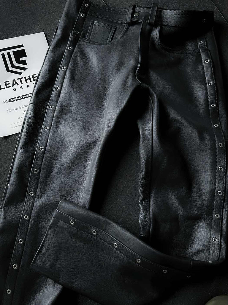 Front flat lay of black leather fetish pants with white stitching and belt loops, ideal for gay pants styling and leather gear uniforms.