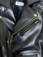 Load image into Gallery viewer, Close-up of a black leather jacket with gold zippers and buttons.

