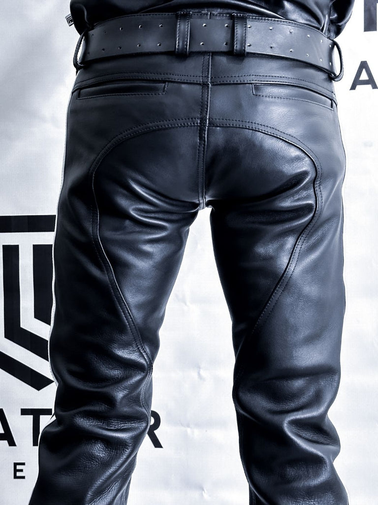 Black leather pants on a person against a gray background with a brand logo.
