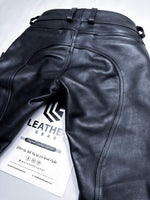 Charger l'image dans la galerie, Black leather pants with a visible 'Leather Gear' tag on a light gray background
