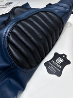 Charger l'image dans la galerie, Close-up of a blue leather seat with a black leather cushion and a visible brand label on a white background.
