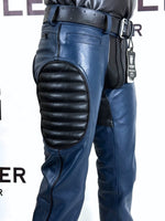 Charger l'image dans la galerie, Blue leather pants with black protective padding on a white background
