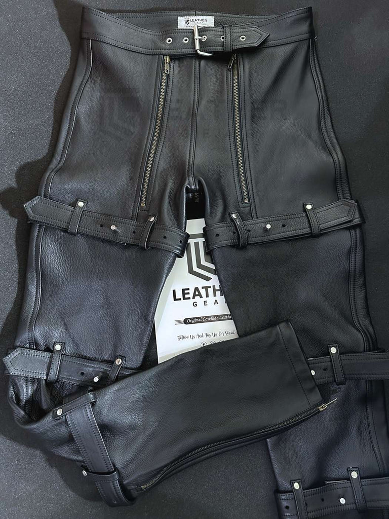 Front view of gay leather bondage pants featuring padded codpiece, metal zippers, and leather straps with padlocks. Handcrafted BDSM fetishwear by Leather Gear.