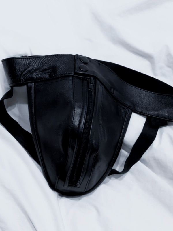 Front view of classic black leather jockstrap featuring metal zipper and stud button waistband – gay fetishwear