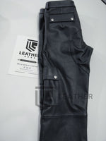 Load image into Gallery viewer, Folded view of black leather cargo pants – gay jeans-inspired fetishwear with zip fly and belt loops
