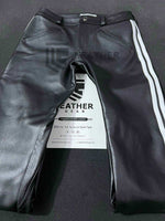 Lade das Bild in den Galerie-Viewer, Flat lay of front side – black leather pants with bold white stripes and double zip fly

